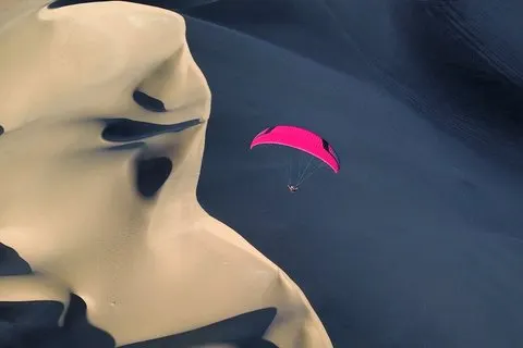 砂漠上空のパラグライダー飛行